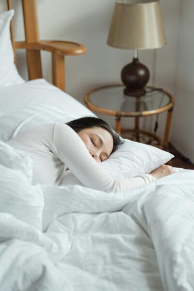 Femme qui dort dans des draps blancs, sommeil