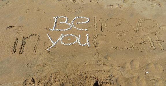 Soi. Believe in yourself — be you” écrit dans le sable — symbole de l’être, pas du faire — Véronique Licini, naturopathe à Lausanne