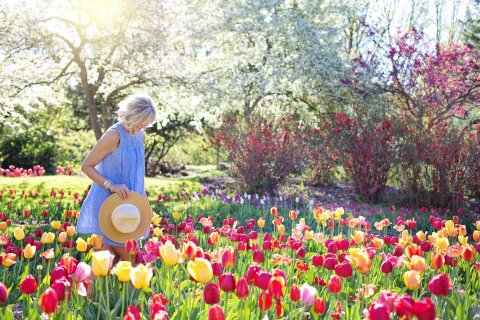 Femme souriante dans un jardin fleuri au printemps
