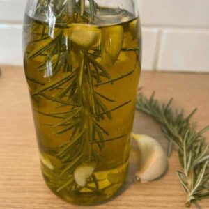 Recette d'huile infusée ail. Bouteille d'huile d'olive avec ail et romarin
