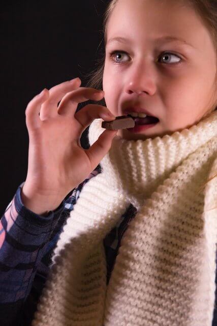 Manger pour calmer des émotions pénibles. Enfant en train de manger — pour illustrer le lien entre nourriture et émotions, même chez les plus jeunes