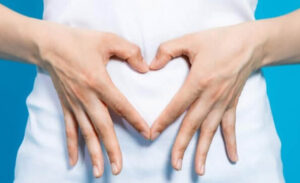 Femme habillée en plan gros plan sur son ventre et mains en cœur