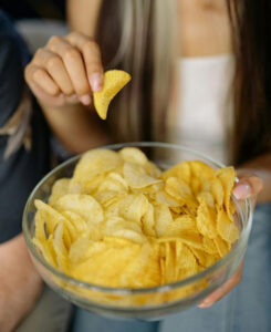 Femme qui mange un bol plein de chips, snacking