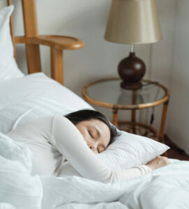 Sommeil. Femme qui dort dans des draps blancs, sommeil