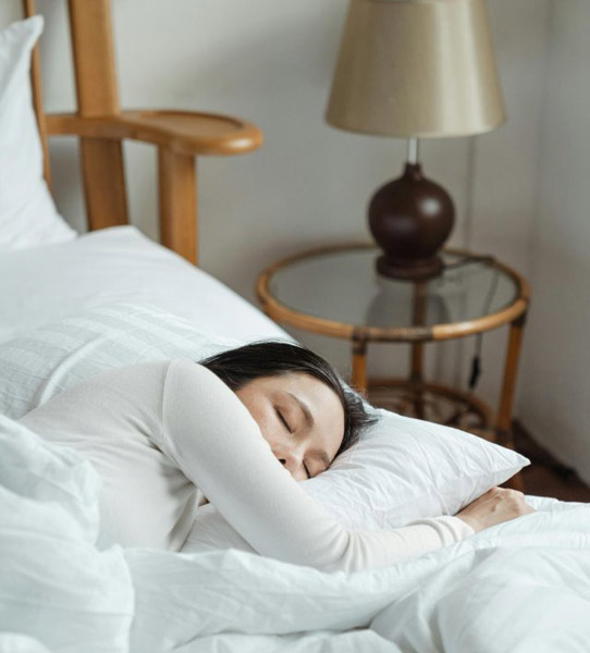 Sommeil. Femme qui dort dans des draps blancs, sommeil